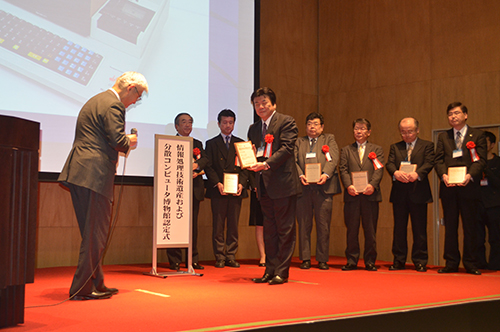 Wataru Hasegawa, President of KCGI and KCG, receives a plaque at Tohoku University in Sendai, March 6, 2013.