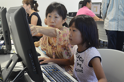 Parents and children work together to create a design.