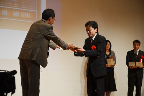 Akira Hasegawa, Chairman of the Board of Directors, receives a certificate of Information Technology Heritage from Chairman Kitsuregawa.