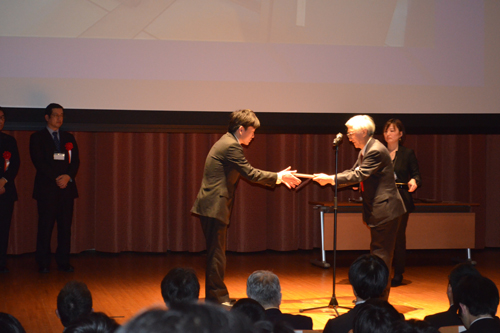 Akira Hasegawa (left), president of Kyoto Computer Gakuin, receives a certificate of 