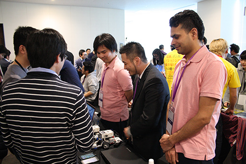 A team of students explaining about robots at an exhibition booth