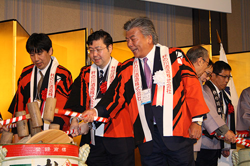 Wataru Hasegawa, Chairman of the Board of Trustees, opening a sake barrel at the reception.