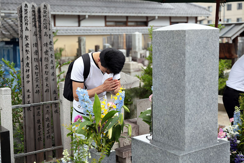 Students and faculty quietly laid hands on the graves at Hyakumanben Chionji Temple.