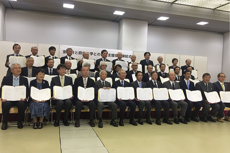 A commemorative photo of representatives of 34 universities and other institutions attending the signing ceremony with Kyoto Governor Takatoshi Nishiwaki and others.Front row, 5th from left: President of KCGI Ibaraki