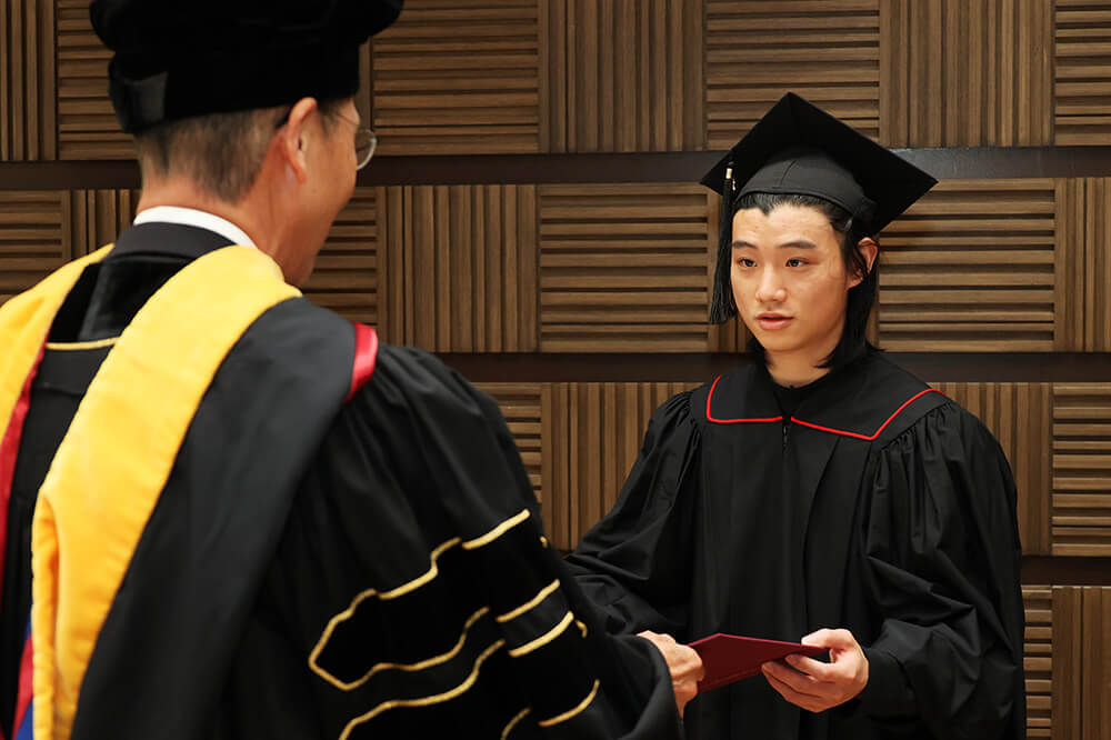 KCGI alumni receiving their degrees from their academic advisors at the new Hyakumanben Campus building of KCGI's main school in Kyoto.