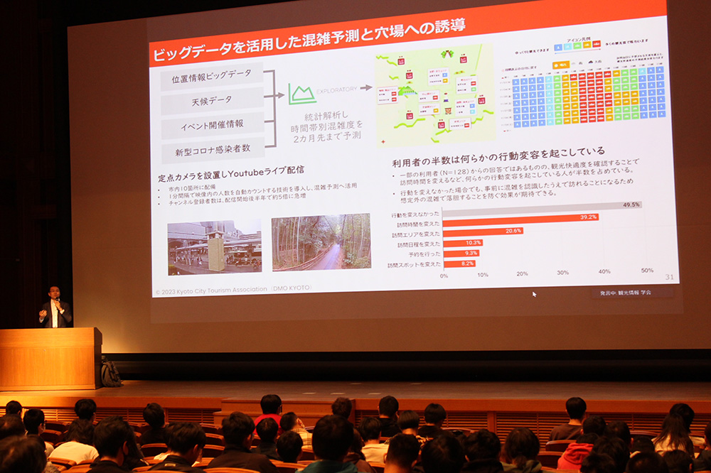 特別講演では京都市観光協会 企画推進課の堀江卓矢さんが「京都DMOの取組」と題して話しました(2023年10月21日,京都情報大学院大学京都駅前サテライト大ホール)