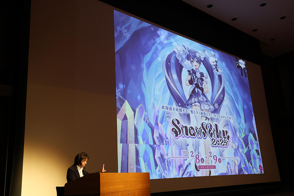 伊藤教授は,バーチャルシンガー「初音ミク」誕生の経緯や成長過程,音声技術・3DCG技術への取り組み,国内外での活躍について映像を交え解説しました。