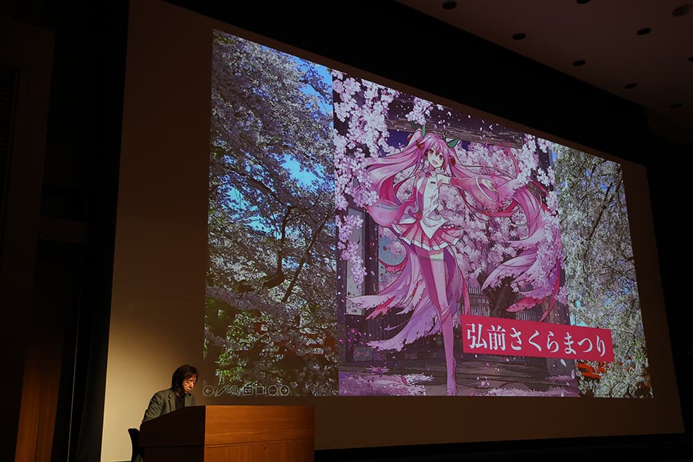 伊藤教授は，バーチャルシンガー「初音ミク」誕生の経緯や成長，音声技術・3DCG技術への取り組み，国内外での活躍について映像を交え解説しました。