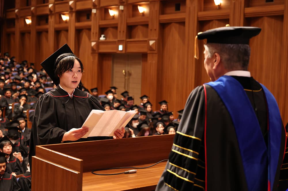 修了の辞を述べるKCGI応用情報技術研究科の古河さん（同）