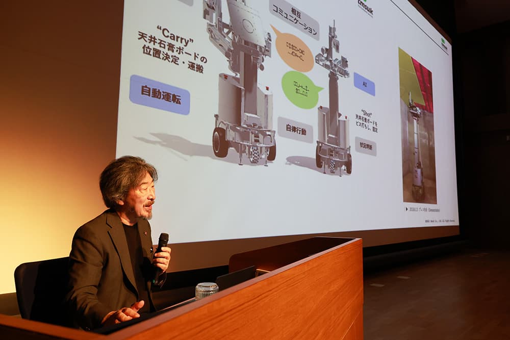 閑堂忌記念講演で「WORKROID」などのサービスロボットについて説明する髙本陽一・株式会社テムザック代表取締役議長（2026年7月3日，KCG京都駅前校・KCGI京都駅前サテライト6階大ホール）